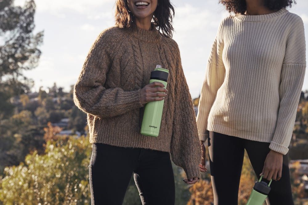 2 hikers on trail with Contigo water bottles in cucumber green
